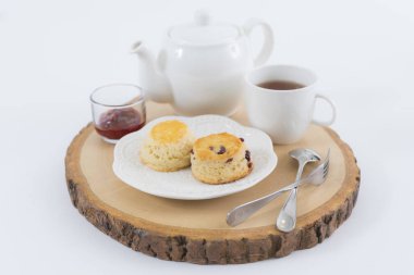 Reçelli çörekler ve masaya yakın çay, beyaz arka planda izole edilmiş.