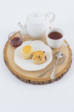 Reçelli çörekler ve masaya yakın çay, beyaz arka planda izole edilmiş.