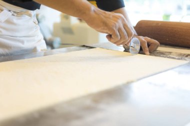 Adam mutfakta ayçöreği hamuru kesiyor. 