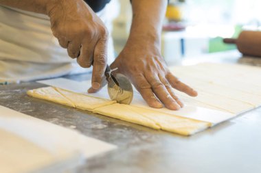 Adam mutfakta ayçöreği hamuru kesiyor. 