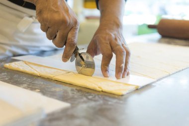 Adam mutfakta ayçöreği hamuru kesiyor. 