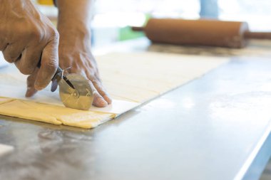 Adam mutfakta ayçöreği hamuru kesiyor. 