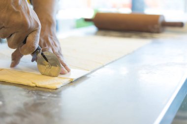 Adam mutfakta ayçöreği hamuru kesiyor. 