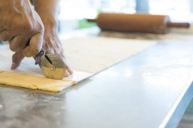 Adam mutfakta ayçöreği hamuru kesiyor. 