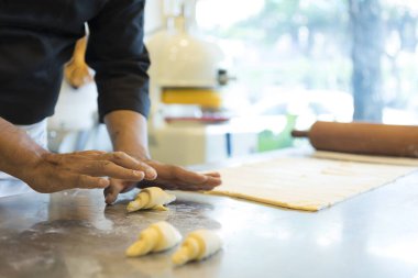 Adam mutfakta kruvasan yapıyor. 