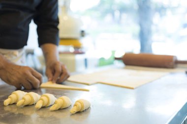 Adam mutfakta kruvasan yapıyor. 