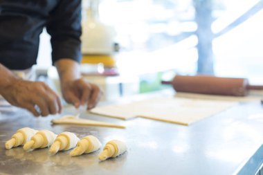 Adam mutfakta kruvasan yapıyor. 