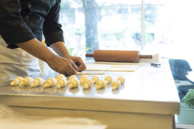 Adam mutfakta kruvasan yapıyor. 