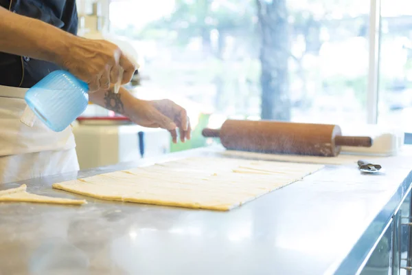 man at kitchen preparing dough for croissant