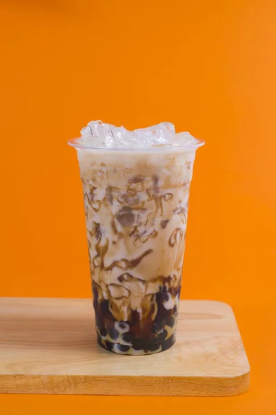 Ice coffee on a wood table with cream showing the texture and refreshing look of the drink, with a clean background.