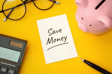 Sarı Arkaplanda Piggy Bank ve Hesap Makinesi.