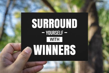 El ele tutuşan siyah kağıt. Etrafını kazananlarla çevirin..