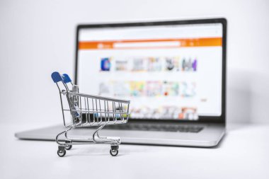 Shopping Cart and Laptop. Online Marketplace Website on Laptop Screen.