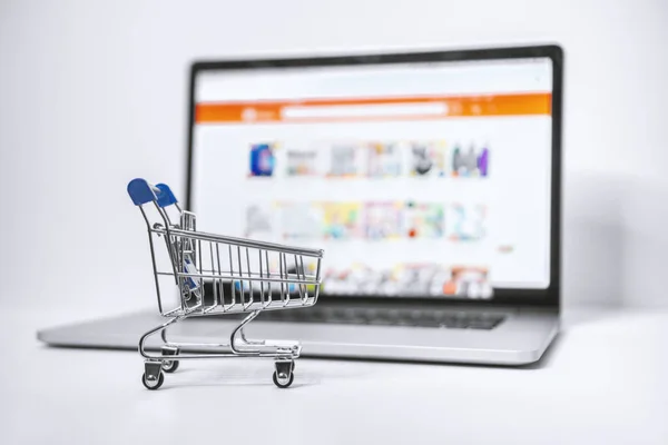 Shopping Cart and Laptop. Online Marketplace Website on Laptop Screen.