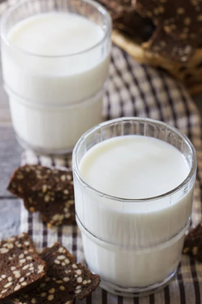 Bicchieri con latte e pane di segale secco a fette — Foto Stock