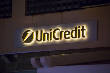 Castelmola, SICILY, ITALY - SEPTEMBER 26, 2019: Unicredit logo on the facade of the office in the city of Castelmola in Italy Sicily clipart