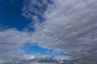 Gökyüzünde beyaz desenli bulutlar, yaz mevsiminin doğal arka planına zıt.