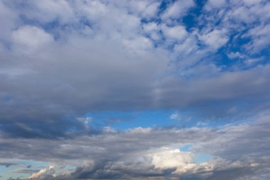 Gökyüzünde beyaz desenli bulutlar, yaz mevsiminin doğal arka planına zıt.