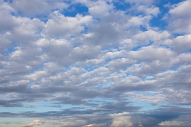 Gökyüzünde beyaz desenli bulutlar, yaz mevsiminin doğal arka planına zıt.