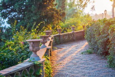 Parkta gün batımında İtalya 'daki parkta Sicilya Villa Comunale Di Taormina' da
