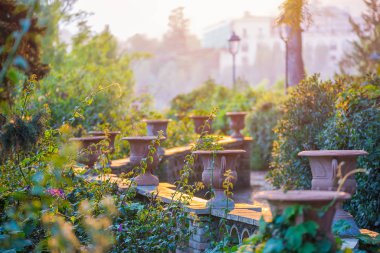 Parkta gün batımında İtalya 'daki parkta Sicilya Villa Comunale Di Taormina' da