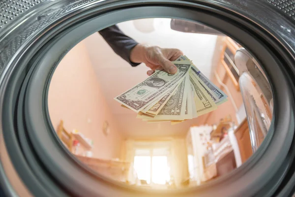 男人把钱扔进洗衣机 非法创业的概念 违法逃税 — 图库照片