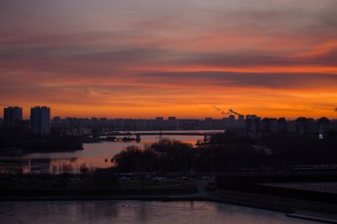 Kuşbakışı bir bakışla şehri aydınlatan parlak bir şafak. Sabahın köründe evlerin üzerinde renkli bir gökyüzü.