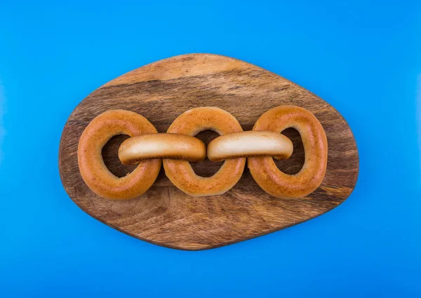 Fried Russian Bagels Blue Wooden Background Form Chain Concept Blockchain — Stock Photo, Image