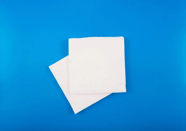 蓝色背景上孤立的一堆白色餐巾纸 — 图库照片