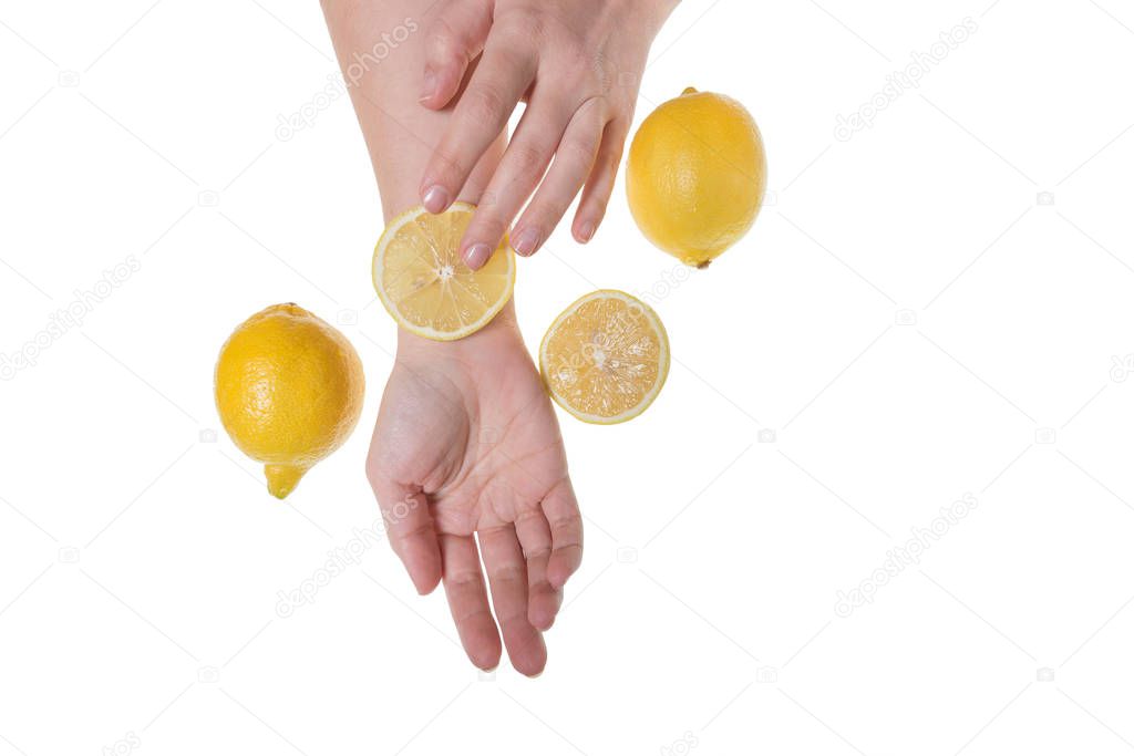 Girl holding hands on table with fruit, concept of cosmetic procedures and rejuvenation, lemon and hands isolated on white background, photo for blogs and natural cosmetics
