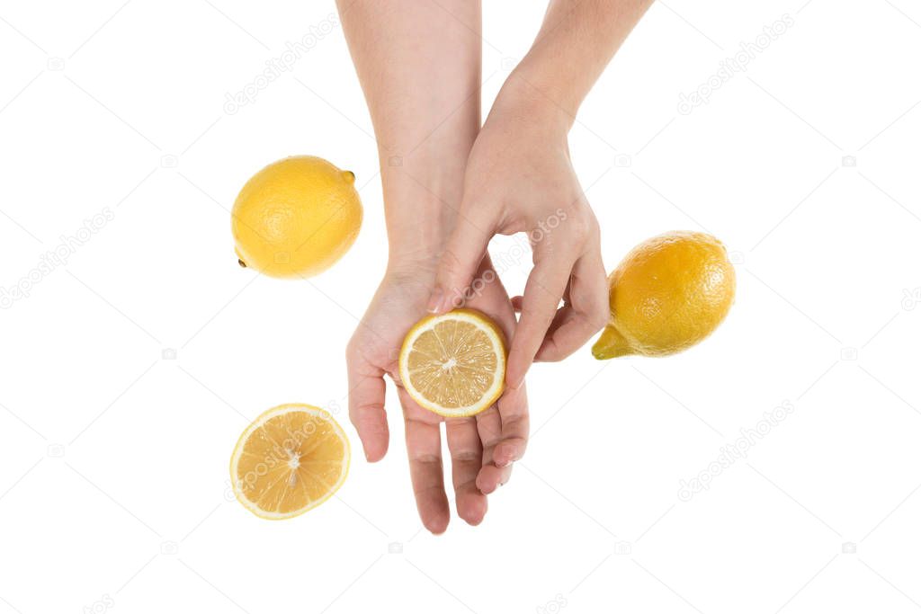 Girl holding hands on table with fruit, concept of cosmetic procedures and rejuvenation, lemon and hands isolated on white background, photo for blogs and natural cosmetics