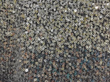 Pullu giysilerin soyut dokusu, parti için ceket ve kıyafet seçimi, parlak arka plan, bir kadın kıyafetlerin dokusunu elleriyle hisseder.