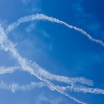 Trilha de inversão de nuvens do avião contra o céu azul