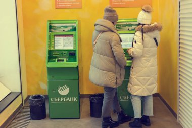 MOSCOW, RUSSIA - JANUARY 4, 2020: People withdraw cash and use a Sberbank ATM at a branch on Tverskaya street in Moscow