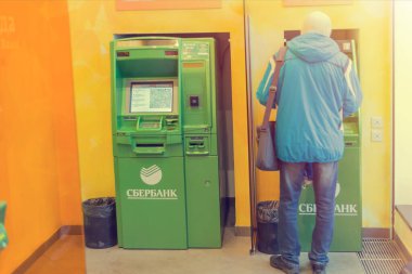 MOSCOW, RUSSIA - JANUARY 4, 2020: People withdraw cash and use a Sberbank ATM at a branch on Tverskaya street in Moscow