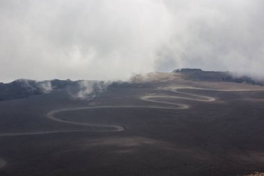 Etna volkanı, İtalya 'nın Sicilya bölgesinde bulutlara ve gökyüzüne beyaz duman ve gri kül püskürtür.