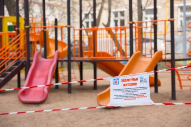 MOSCOW, RUSSIA - 6 Nisan 2020: Parkın yakınındaki oyun parkında kırmızı ve beyaz şerit uyarısı, Moskova 'da koronavirüs salgını tehdidi nedeniyle sokaktaki oyun alanını ziyaret etme yasağı