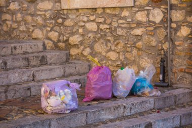 İtalya 'nın Sicilya adasındaki Taormina' da eski bir binanın merdivenlerinde çöp torbaları..