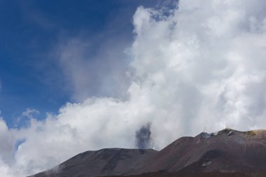 Etna volkanı, İtalya 'nın Sicilya bölgesinde bulutlara ve gökyüzüne beyaz duman ve gri kül püskürtür.