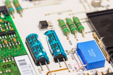 MOSCOW, RUSSIA - APRIL 5, 2019: Part of the circuit Board from electronics or home appliances with radio components and capacitor, repair and diagnostics of components clipart