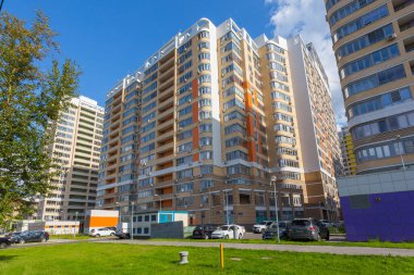 MOSCOW, RUSSIA - 6 AĞUSTOS 2019: Parlak bir günde Moskova 'nın merkezinde park ve avlu, başkentte kiralık daireler ve daireler bulunan modern bir konut binasının cephesi