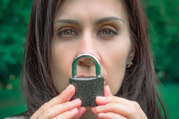 Conceptual portrait of a woman keeping silence with lock over he