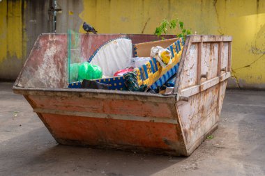 Çöpteki eski kanepe. Bahçedeki çöp tenekesi: eski kanepe, torbalar, plastik. Çöpte canlı güvercin. Ekoloji ve atık ayıklama sorunu. Rusya, Tataristan, 7 Ağustos 2019