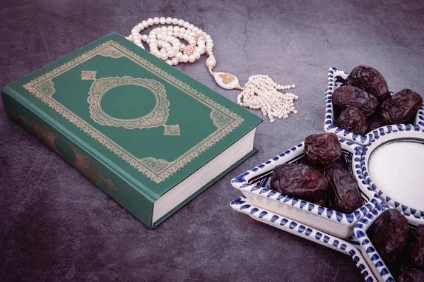Moslem islamischen Glauben Konzept quran Buch, weißer Rosenkranz mit der Inschrift Allah, Daten in der Schale im arabischen Stil. grauer dunkler Betonhintergrund. Layout und Platz für Text. gemildert — Stockfoto