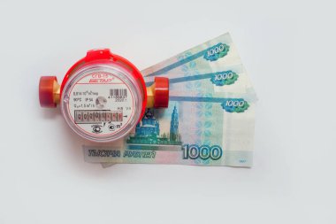 Sıcak su ve banknotların hesaplanması için yeni sayaç. Beyaz arka planda izole edilmiş 2000 Rus rublesi. Rusya 'da kullanılan 2020 sayacı. Su sayacı kullanırken para biriktirme kavramı. Rusya