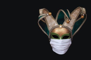              Siyah arka planda izole edilmiş tıbbi koruyucu maske takan klasik Venedik karnaval maskesi. İtalya 'da koronavirüsün yayılması konsepti.                  