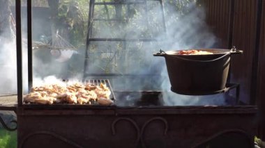 Pilav ve et yanıyor. Bir kadın hamakta, bebek arabasındaki bir çocuğun yanında uyuyor. Mutlu annelik kavramı. Yaz zamanı. Karantina sırasında avluda yemek pişirmek.