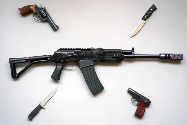 Yaban domuzu makineli tüfeği, ordu bıçakları ve gri arka planda tabancalar. İzole edilmiş. düz yat — Stok fotoğraf