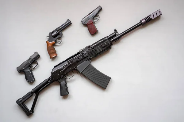 Close-up of a boar machine gun and pistol on a gray background. Isolated. flat lay. — Stock Photo, Image