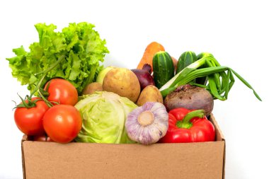 Beyaz arka planda karton bir kutuda taze sebzeler. Taze ve sağlıklı yiyecek teslimatı kavramı.